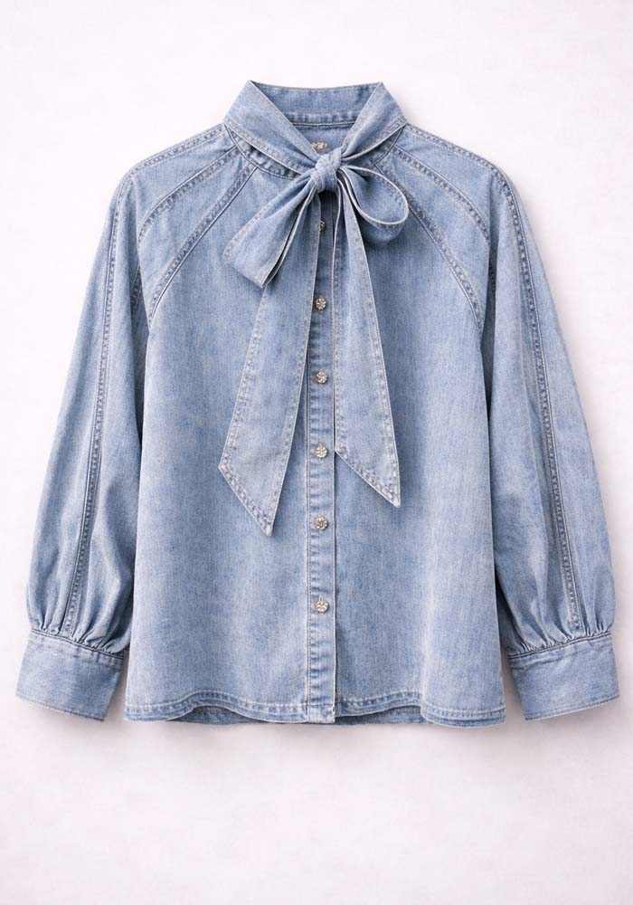 Γυναικείο denim πουκάμισο Bow σε ανοιχτό blue με φιόγκο στον λαιμό, balloon μανίκια και μεταλλικά κουμπιά μπροστά.