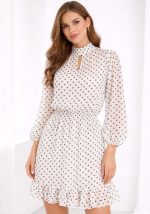 Λευκό mini φόρεμα με μαύρο πουά, μακριά μανίκια, δέσιμο στον λαιμό και βολάν στο τελείωμα σε ρομαντικό στυλ.