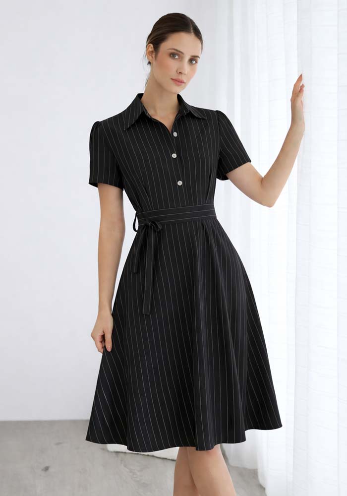 Μαύρο midi φόρεμα με κάθετες ρίγες, κοντά μανίκια, χρυσά κουμπιά και υφασμάτινη ζώνη στη μέση.