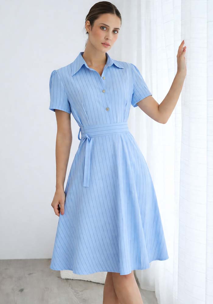 Σιέλ midi φόρεμα με κάθετες ρίγες, κοντά μανίκια, χρυσά κουμπιά και υφασμάτινη ζώνη στη μέση.