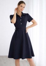 Μπλε navy midi φόρεμα με κάθετες ρίγες, κοντά μανίκια, χρυσά κουμπιά και υφασμάτινη ζώνη στη μέση.